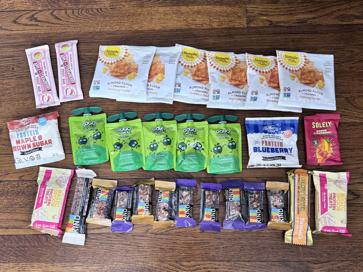 Gluten-free crackers, snack bars, oatmeal and fruit pouches laid out in rows